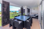Ocean view terrace with Jacuzzi, lounge chairs, and patio table with seating for 8